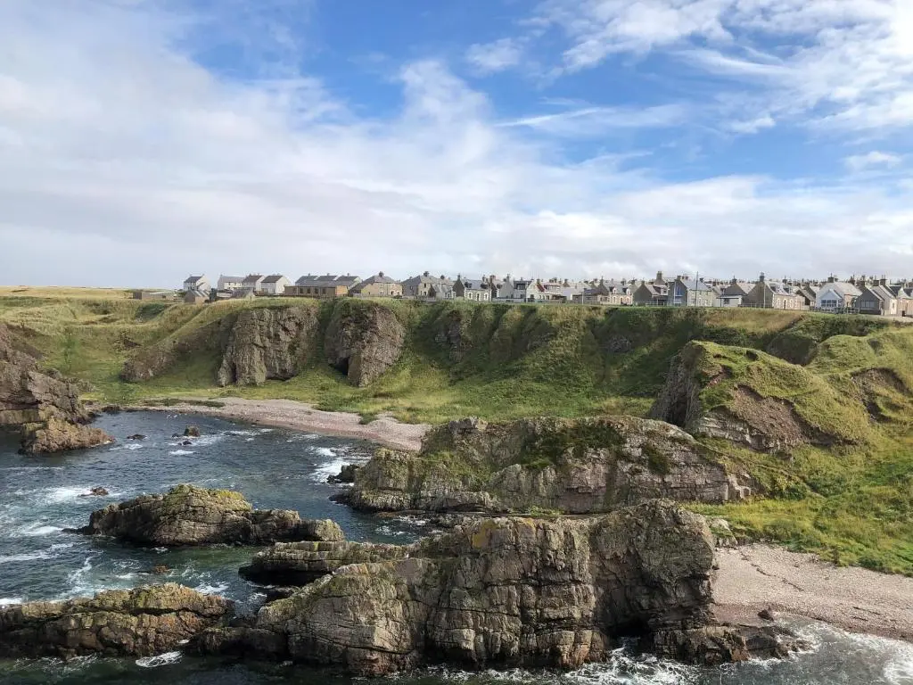 a view of a beach with rocks and houses at 4 Gordon Street in Buckie