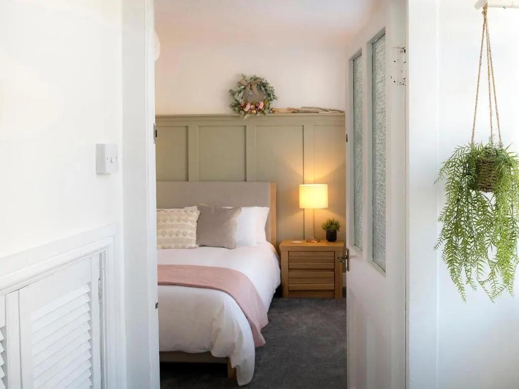 a bedroom with a bed and a table with a lamp at Sandpiper Cottage in Buckie
