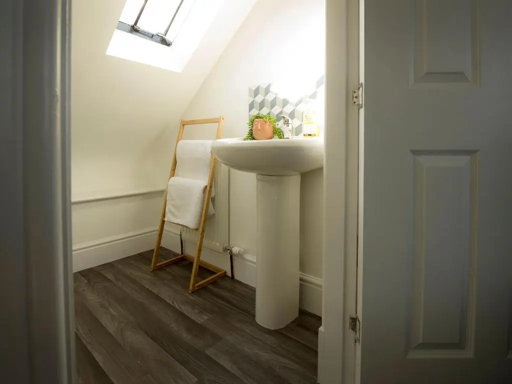 a bathroom with a sink and a chair at Sandpiper Cottage in Buckie