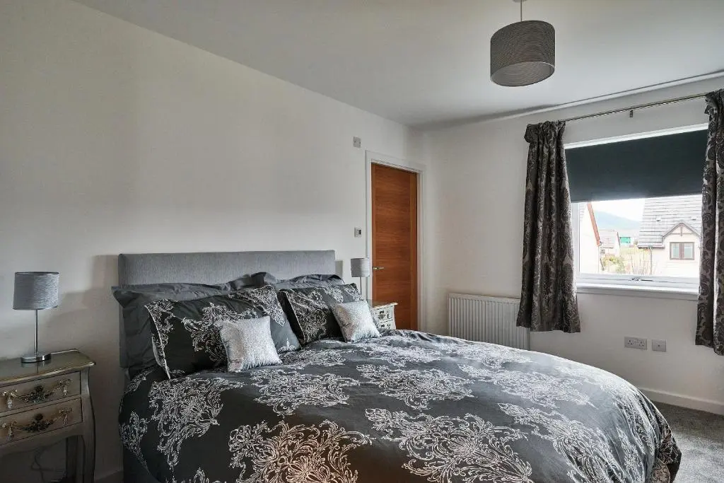 a bedroom with a bed and a window at Aviemore apartment (pet friendly) - sleeps 4 in Aviemore
