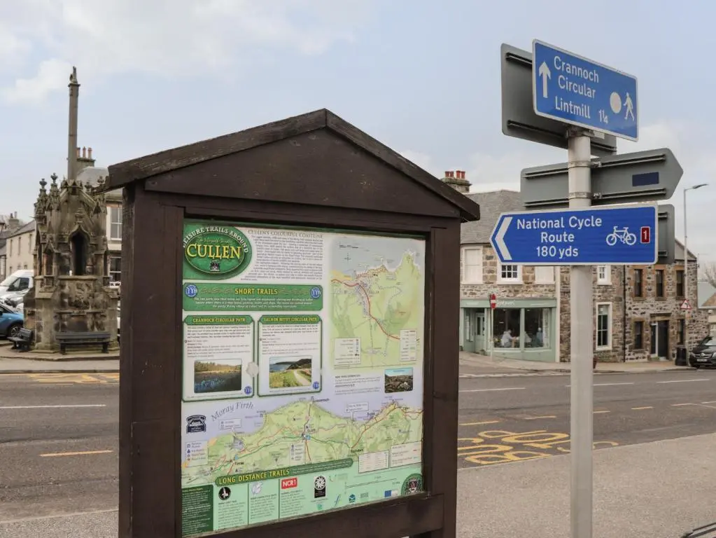 a bus stop sign with a map on a street at Eider Cottage in Buckie