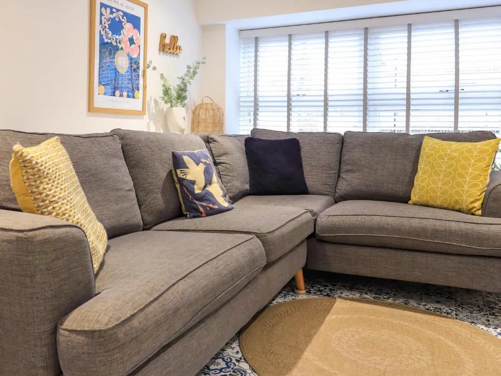 a couch with pillows on it in a living room at Eider Cottage in Buckie