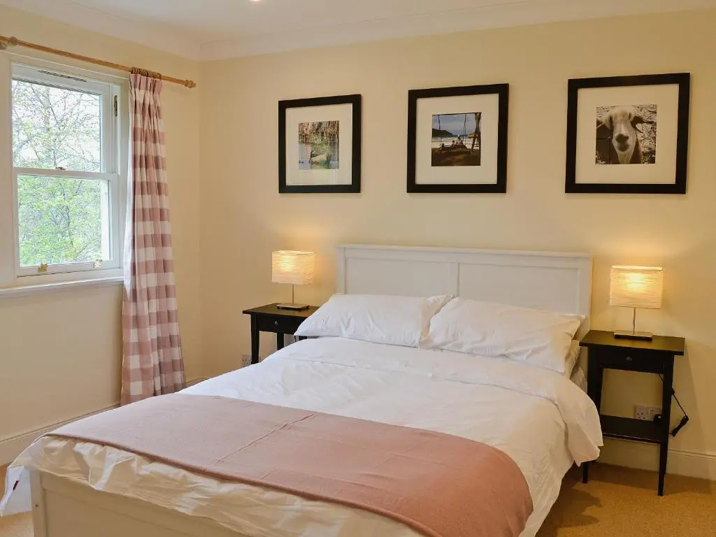 a bedroom with a large bed with two lamps at Haugh House in Aberlour