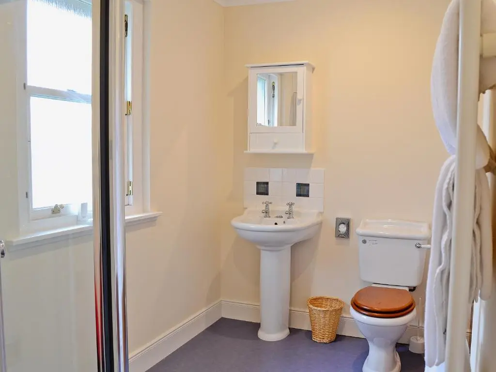 a white bathroom with a toilet and a sink at Haugh House in Aberlour