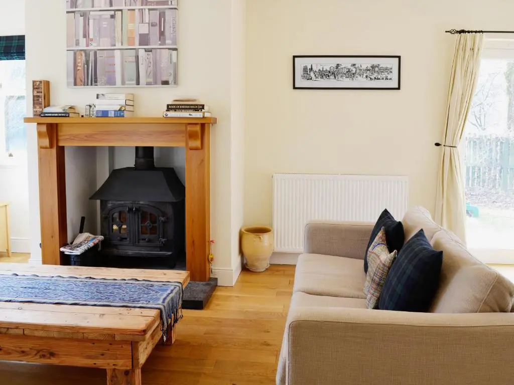 a living room with a couch and a fireplace at Haugh House in Aberlour