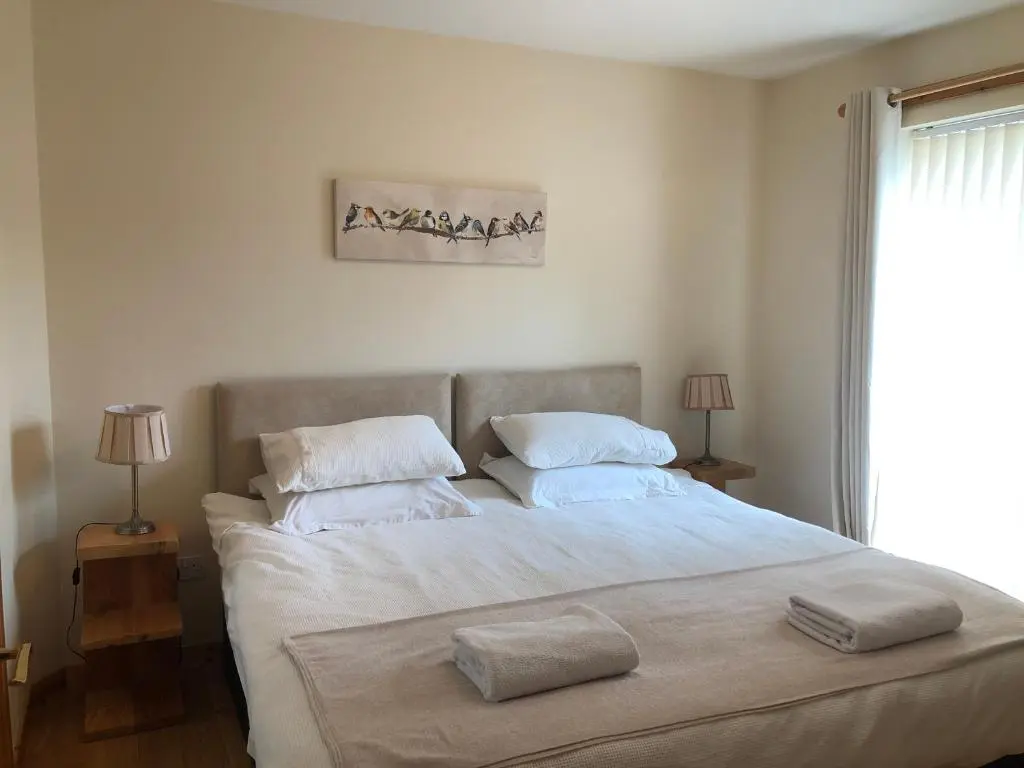a bedroom with a large bed with two towels on it at Tulach Ard in Grantown on Spey