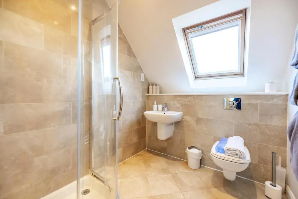 a bathroom with a shower and a toilet and a sink at Stunning Country House - Cinema, Games Room & Hot Tub in Inverurie