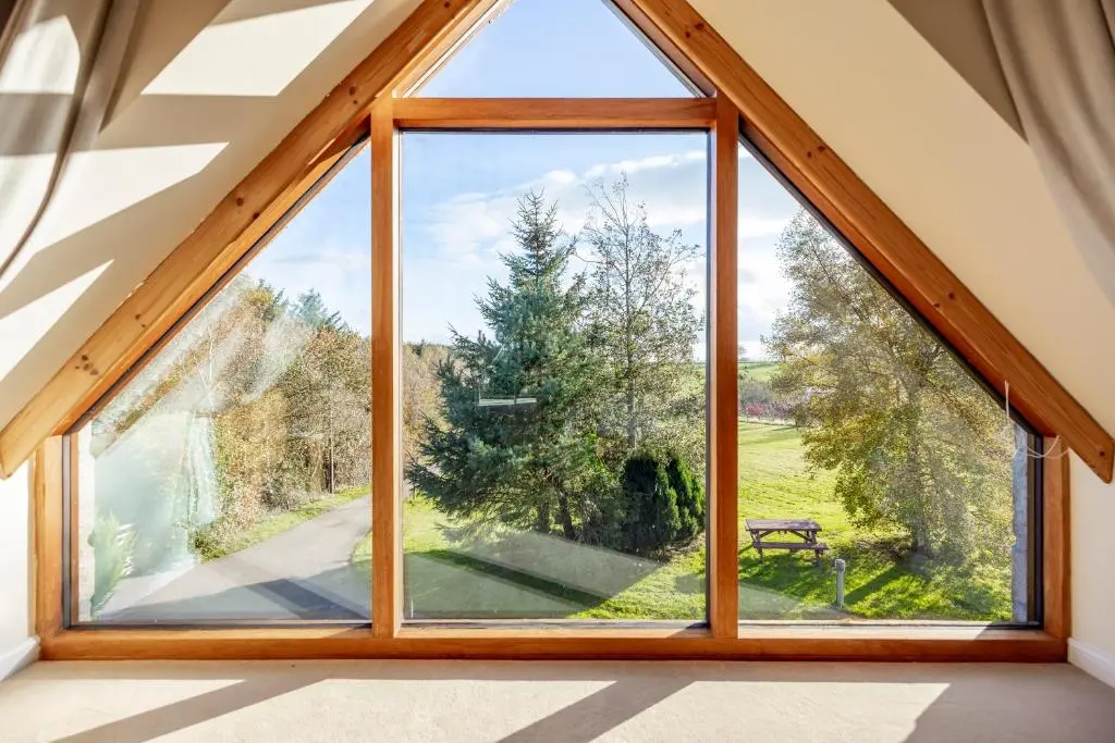 a window in a house with a view of a park at Stunning Country House - Cinema, Games Room & Hot Tub in Inverurie