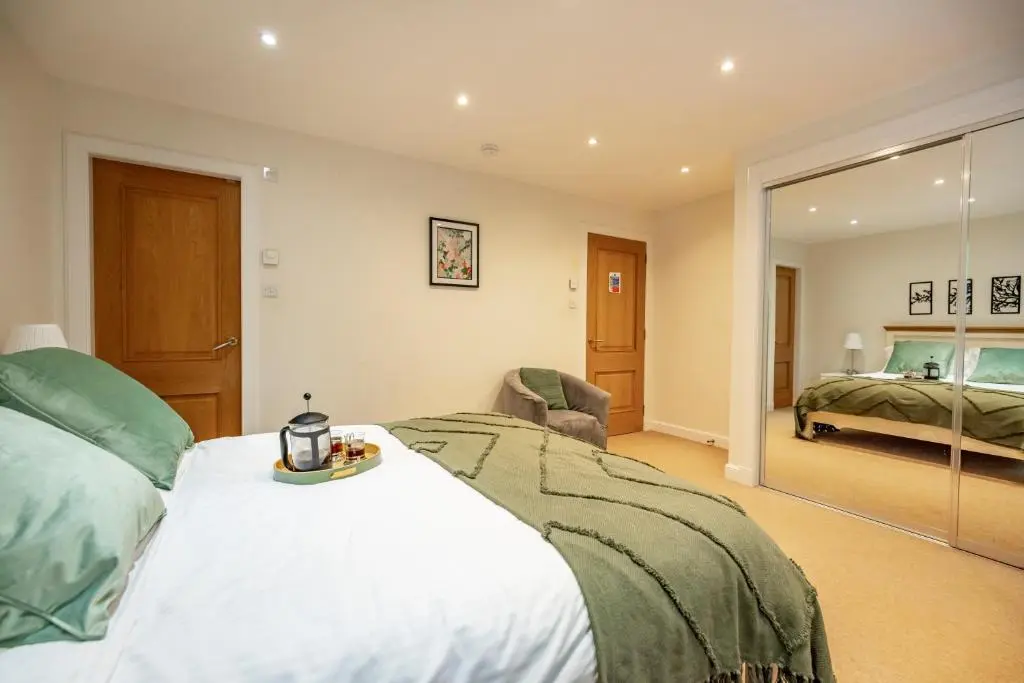a bedroom with a large bed and a mirror at Stunning Country House - Cinema, Games Room & Hot Tub in Inverurie