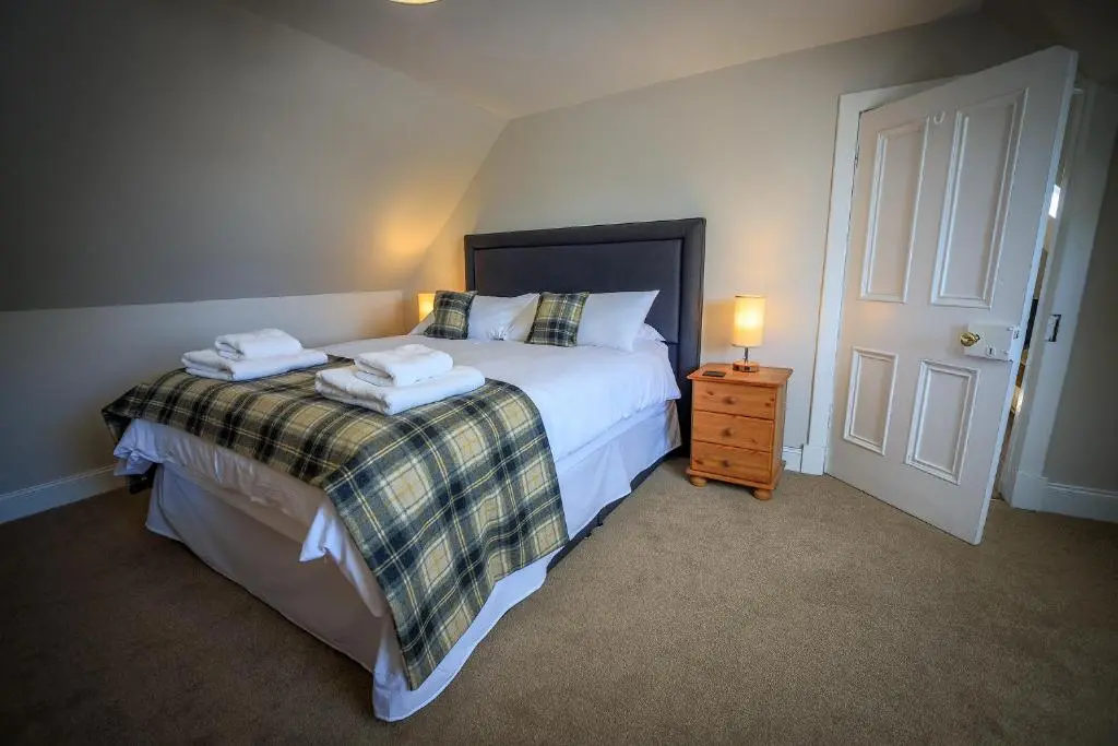 a bedroom with a bed with two towels on it at Cosy Cottage in Fishertown, Nairn - Free Parking & Pets welcome in Nairn