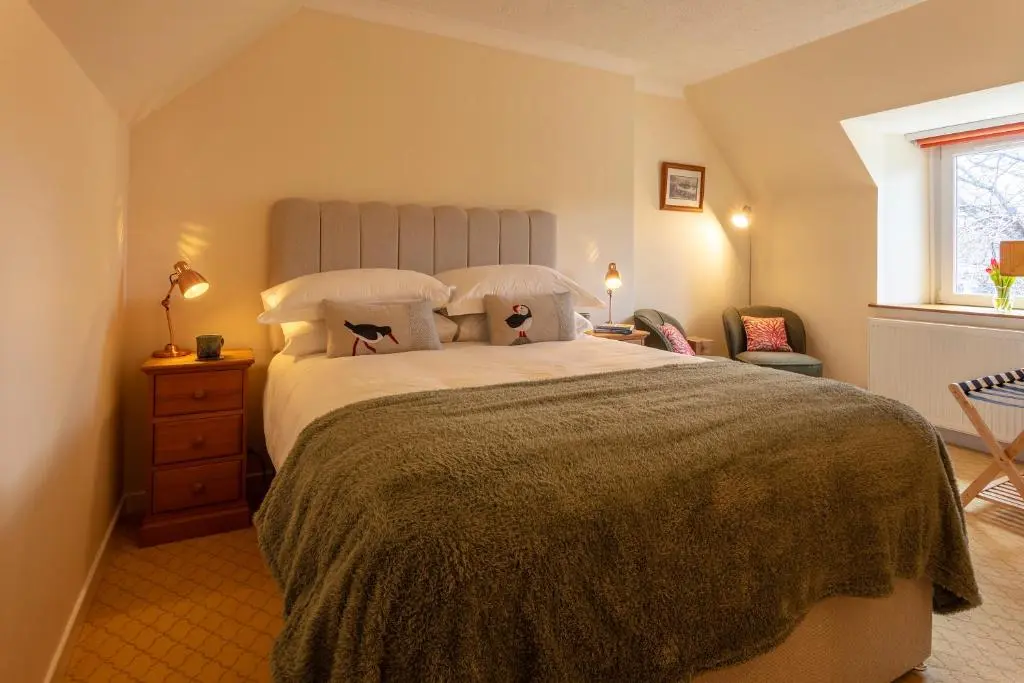 a bedroom with a large bed and a window at The Ullapool Rooms in Ullapool