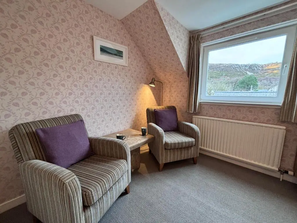 a living room with two chairs and a window at The Ullapool Rooms in Ullapool