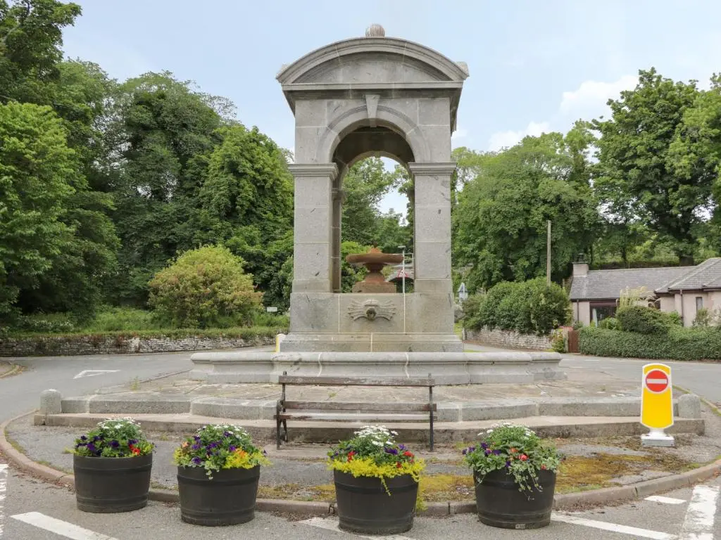 a monument in a park with flowers in pots at The Steading in Rogart