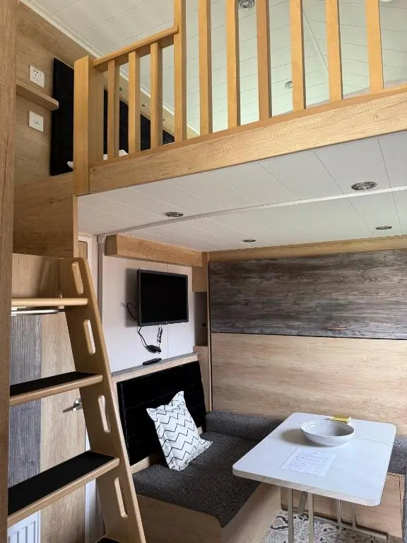 a tiny house with a loft bed and a desk at The Willy Gunn Pod - Beautiful, luxury pod in Aberlour