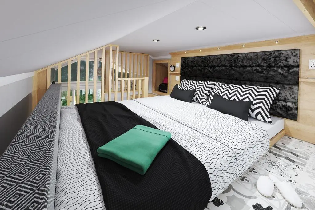 a bedroom with a large bed with a green pillow on it at The Parr Pod - Beautiful, luxury pod in Aberlour