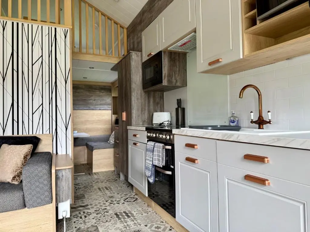 a kitchen with white cabinets and a sink at The Parr Pod - Beautiful, luxury pod in Aberlour