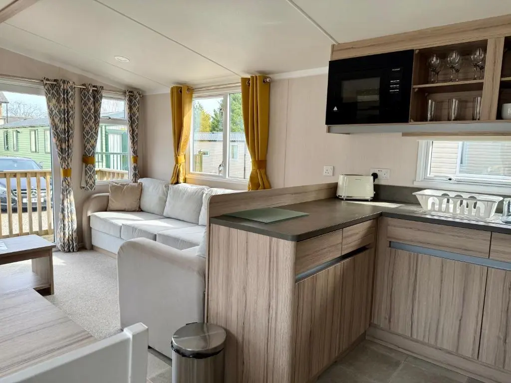 a caravan kitchen and living room with a couch at The Salmon Van - Beautiful, luxury static caravan in Aberlour