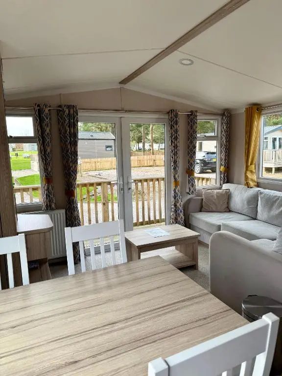 a living room with a couch and a table at The Trout Van - Beautiful, luxury static caravan in Aberlour