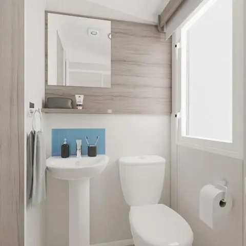 a white bathroom with a toilet and a sink at The Fly Van - Beautiful, luxury static caravan in Aberlour