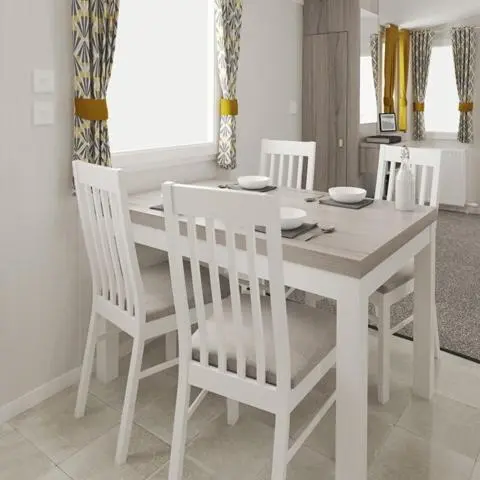 a white dining room table with four white chairs at The Fly Van - Beautiful, luxury static caravan in Aberlour