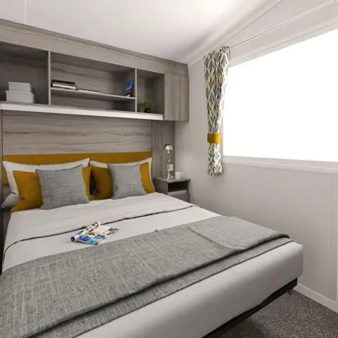 a bedroom with a large bed with a window at The Fly Van - Beautiful, luxury static caravan in Aberlour