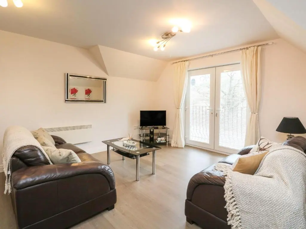 a living room with two couches and a tv at 4 River Court in Invergarry