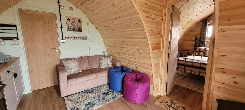 a room with a couch and a chair in a house at Achmeney Glamping larger than Average pod in Halkirk