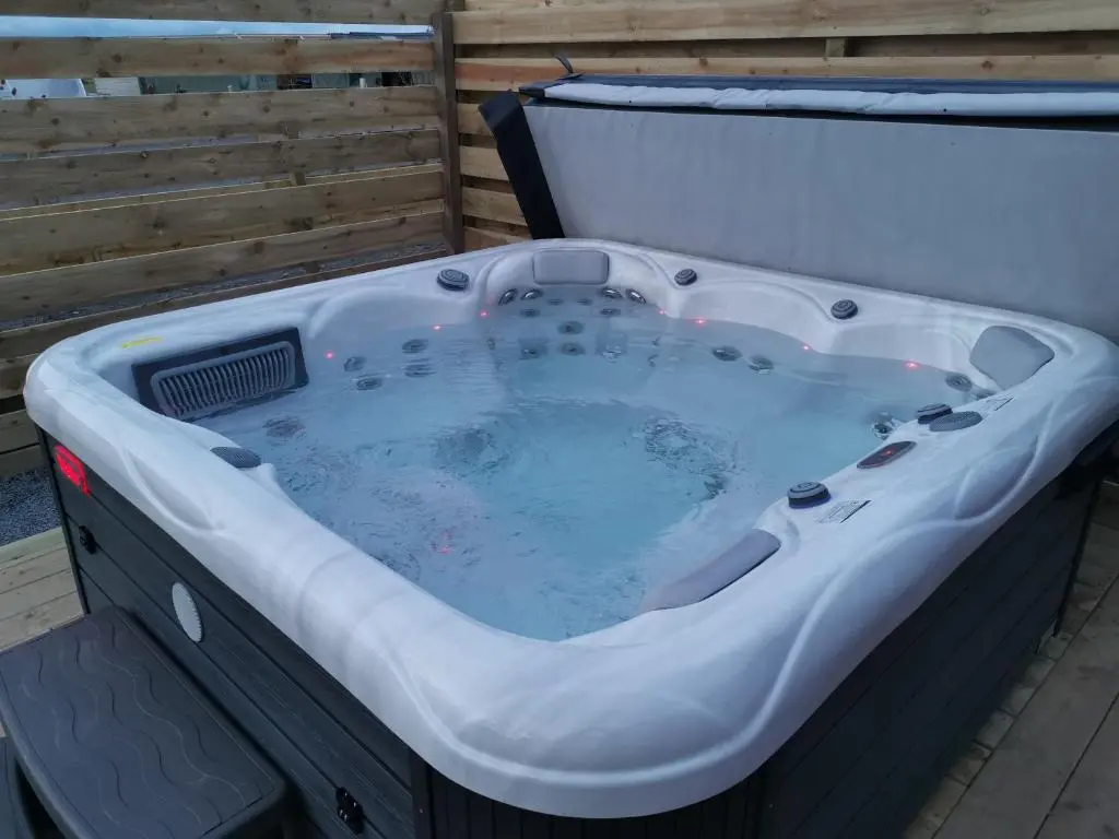 a jacuzzi tub sitting on a deck at Achmeney Glamping larger than Average pod in Halkirk