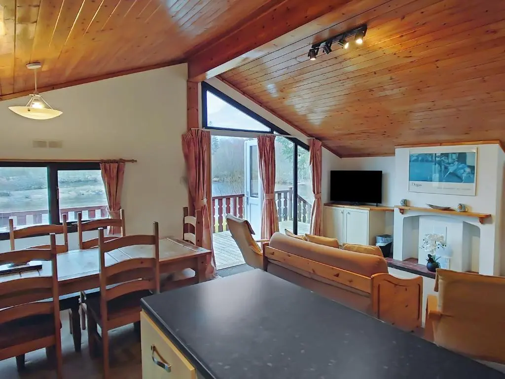 a living room with a couch and a dining room at 27 Aviemore Holiday Park in Aviemore