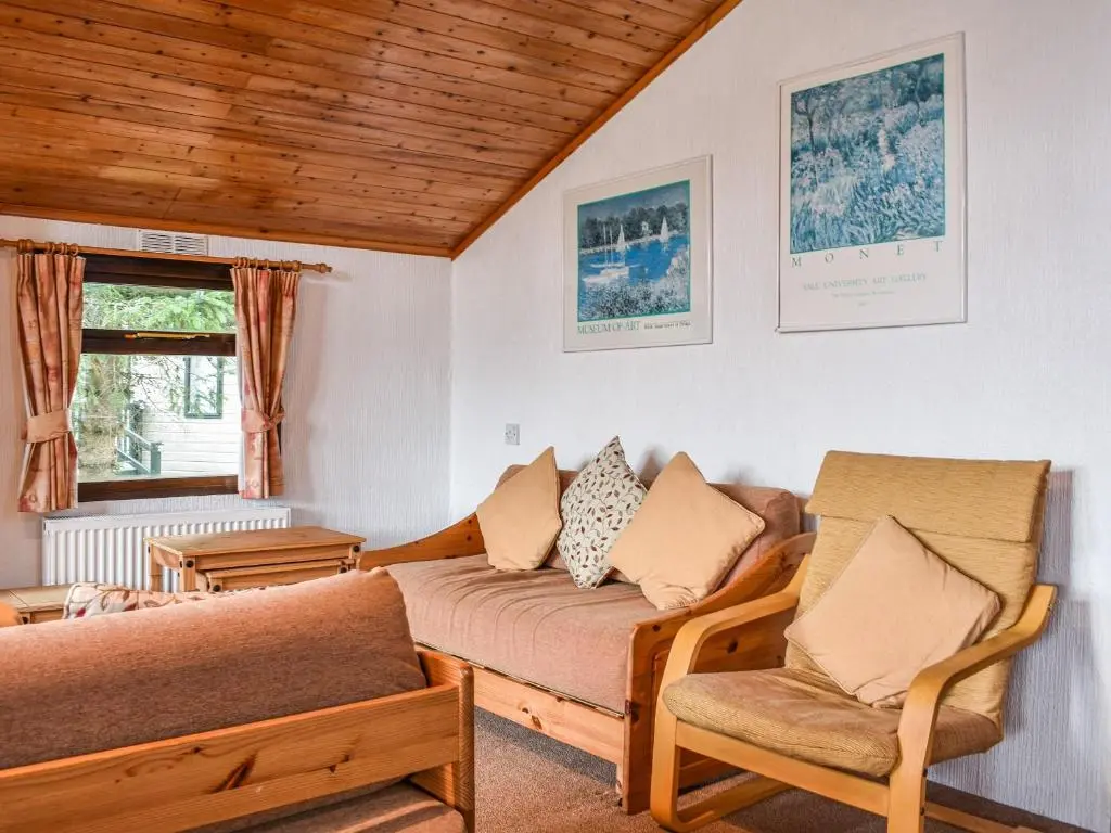 a living room with a couch and two chairs at 27 Aviemore Holiday Park in Aviemore