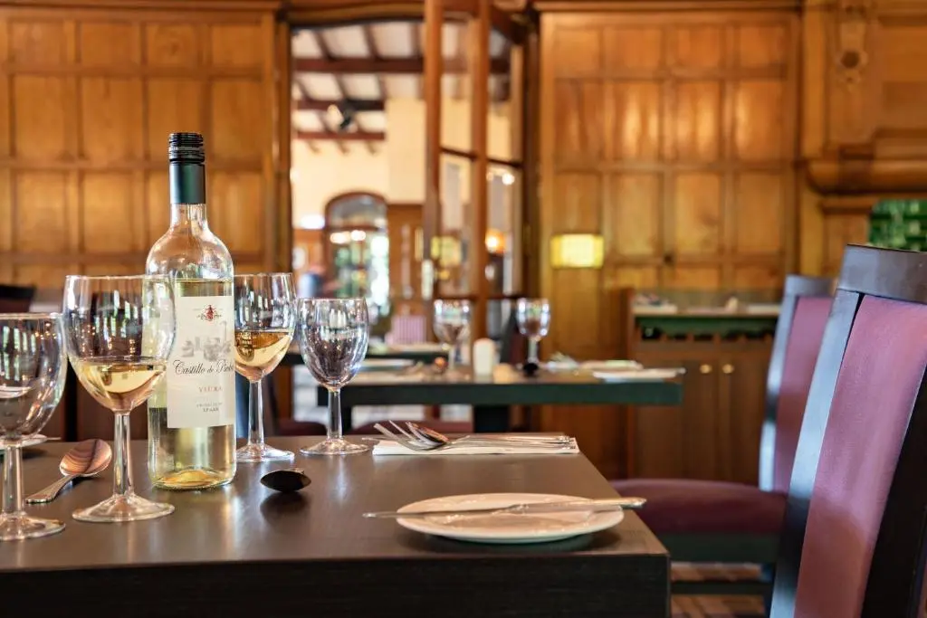 a bottle of wine sitting on a table with wine glasses at The Highland Hotel by Compass Hospitality in Strathpeffer