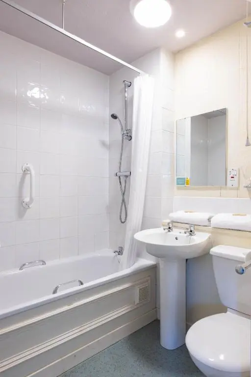 a bathroom with a sink and a toilet and a bath tub at The Highland Hotel by Compass Hospitality in Strathpeffer