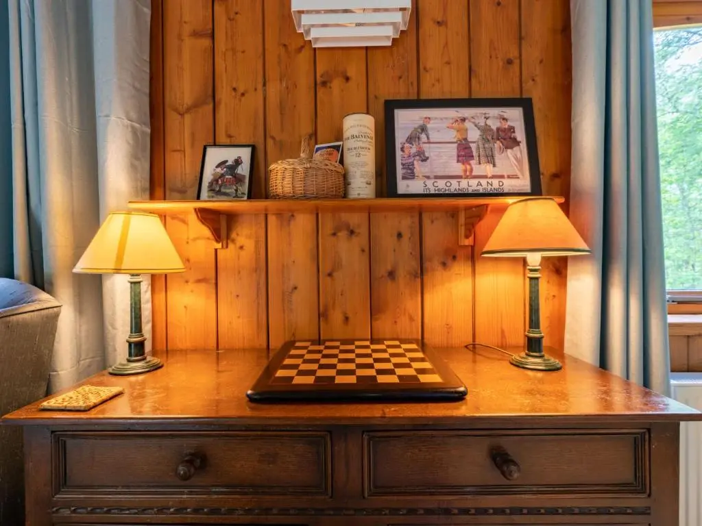 two lamps on a dresser with a chessboard on it at Holiday Home Riverside Cottage by Interhome in Inverness