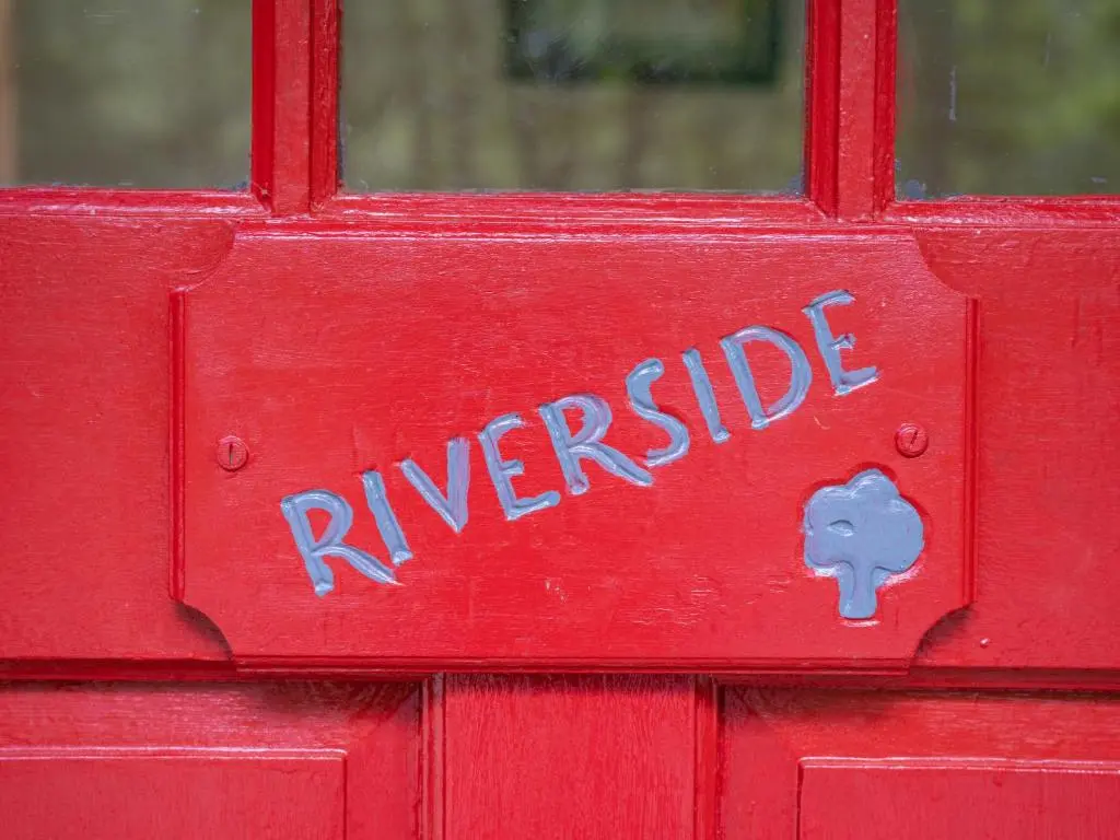 a red door with the words riverride written on it at Holiday Home Riverside Cottage by Interhome in Inverness