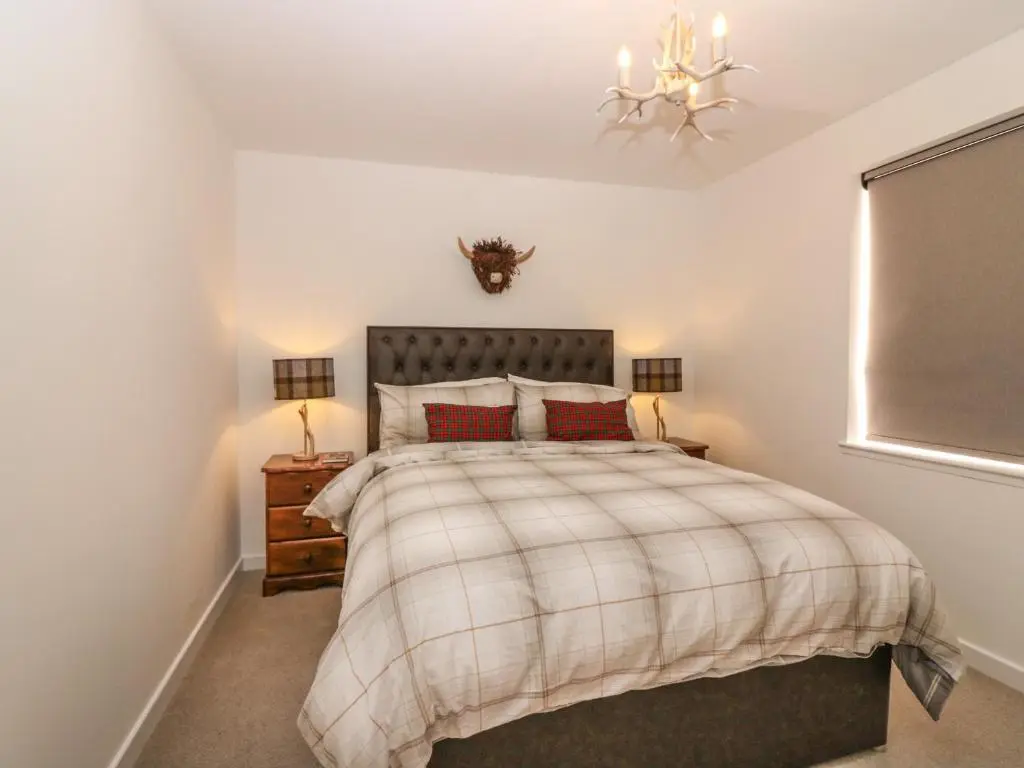 a bedroom with a bed and a chandelier at Bullpens in Banff
