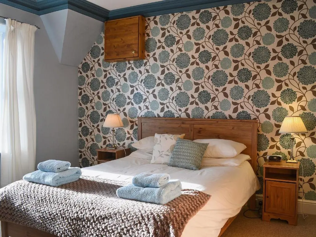 a bedroom with a bed with towels on it at Treetops in Newtonmore