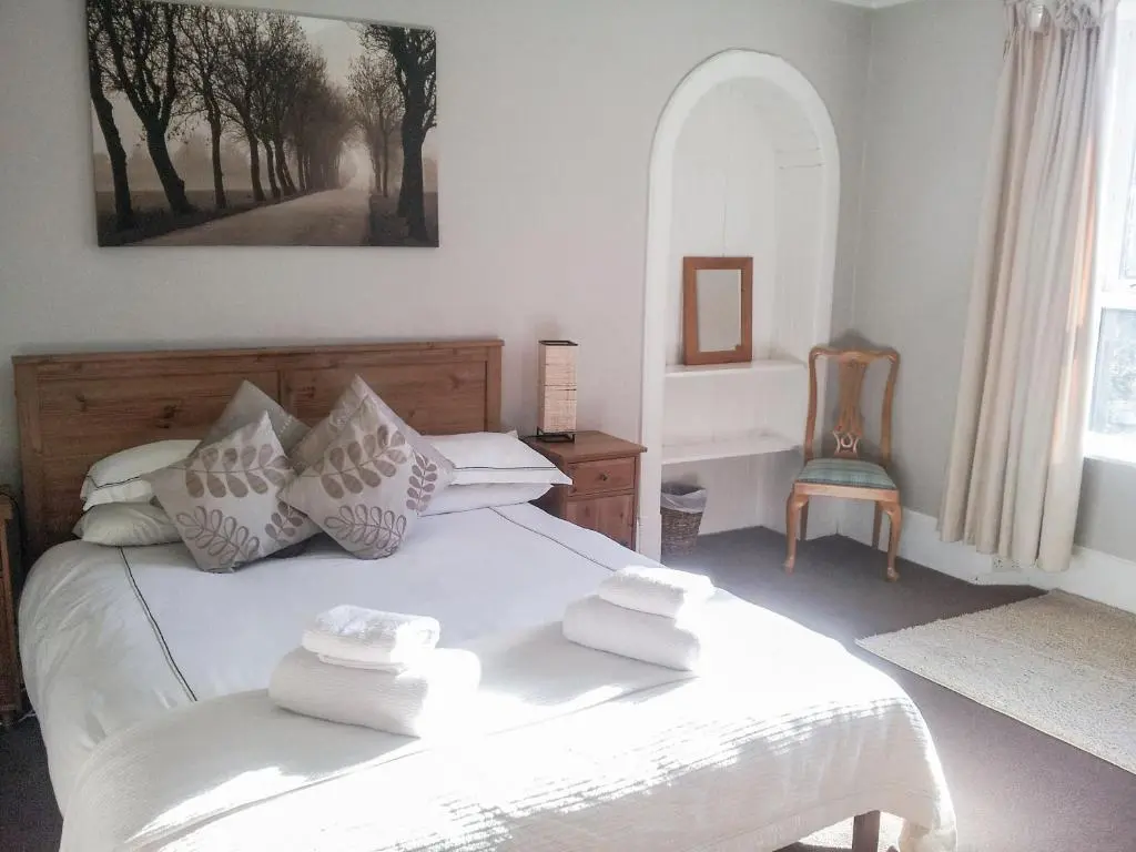 a bedroom with a white bed with towels on it at Treetops in Newtonmore