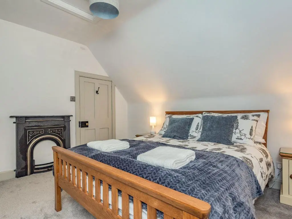 a bedroom with a large bed and a fireplace at East Lodge in Contin