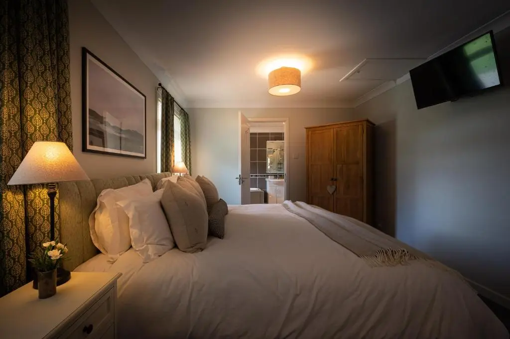 a bedroom with a large white bed and a television at Balmridge House, Loch Ness, Bed & Breakfast in Drumnadrochit
