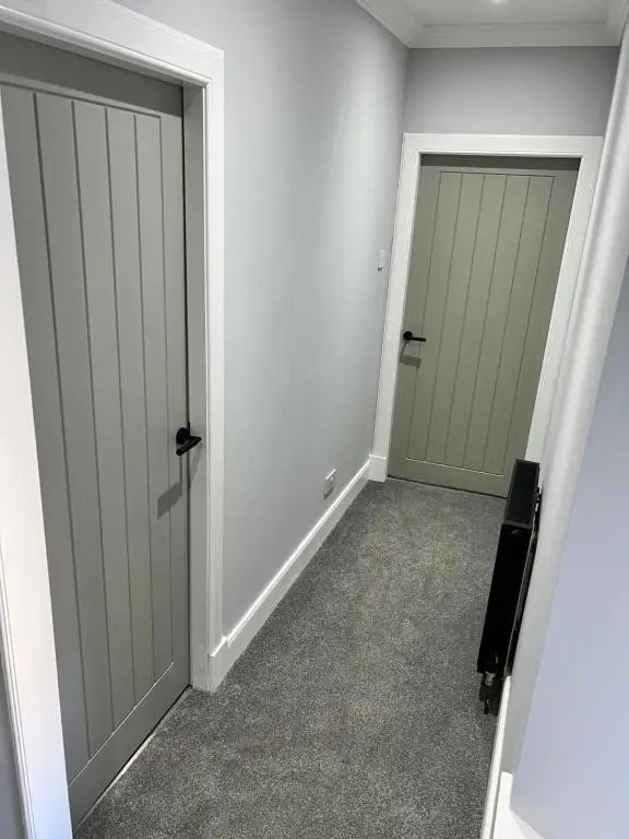 an empty room with two doors and carpet at Town centre 2 bed luxury apartment in Wick