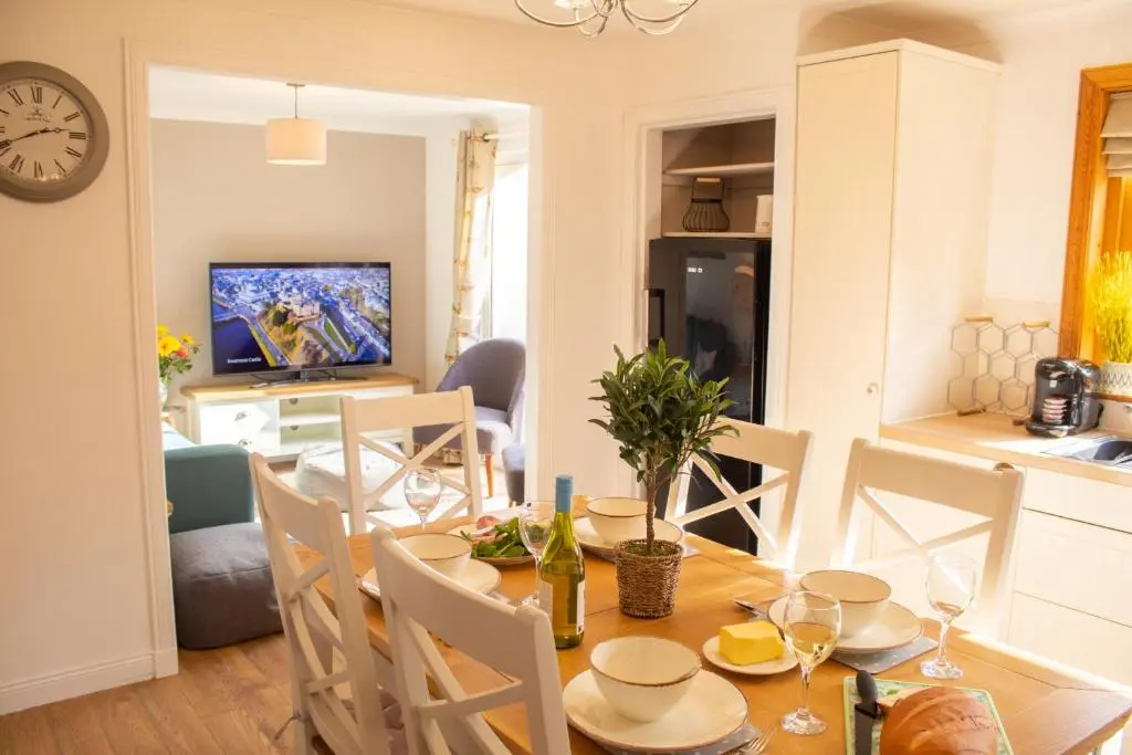 a dining room and kitchen with a table and chairs at Longfield, Daviot in Inverness