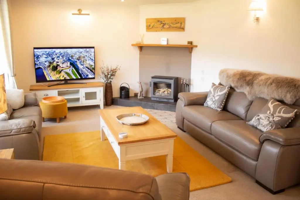 a living room with a couch and a tv at Longfield, Daviot in Inverness