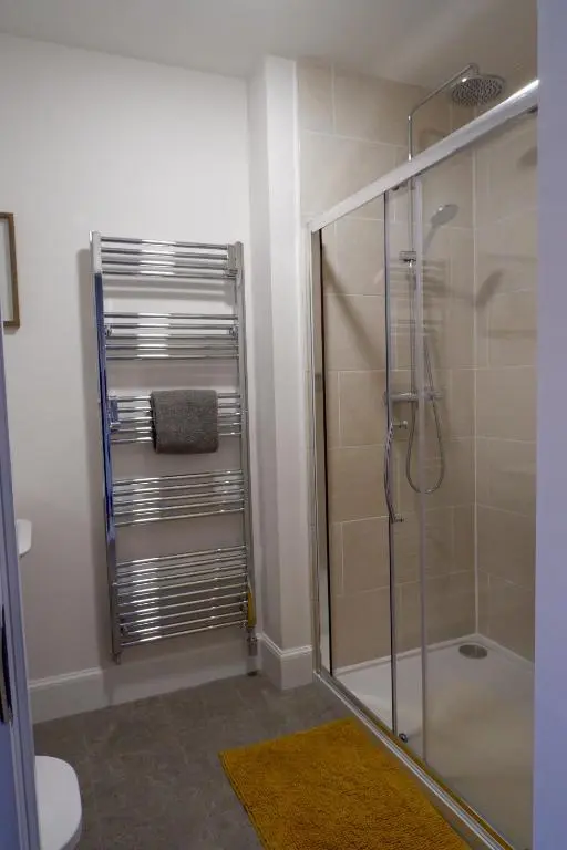 a bathroom with a shower with a glass door at No 7 Quiet, two bedroom Ground Floor Flat in Tornagrain Great for early Airport departures or late flights in Dalcross