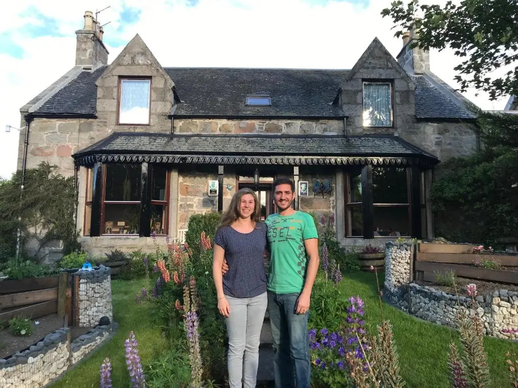 a man and woman standing in front of a house at Butterfly Cottage in Grantown on Spey