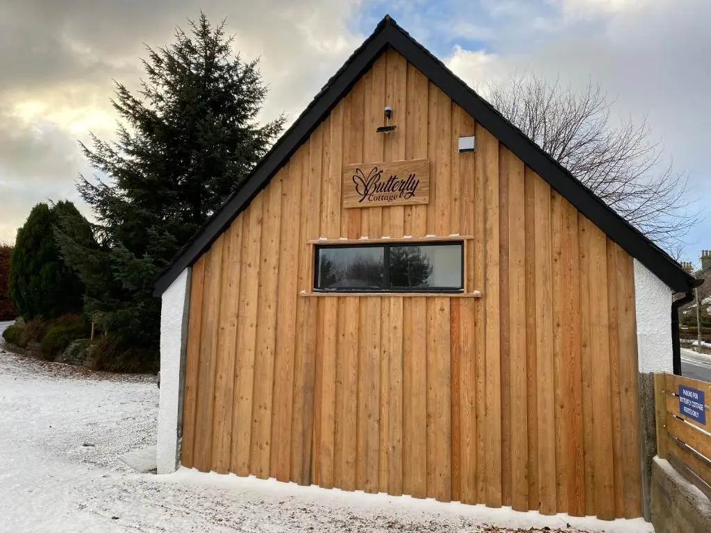 a building with a window on the side of it at Butterfly Cottage in Grantown on Spey
