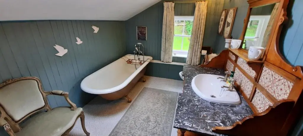 a bathroom with a tub and a sink and a bath tub at East Wing Lickleyhead Castle in Auchleven