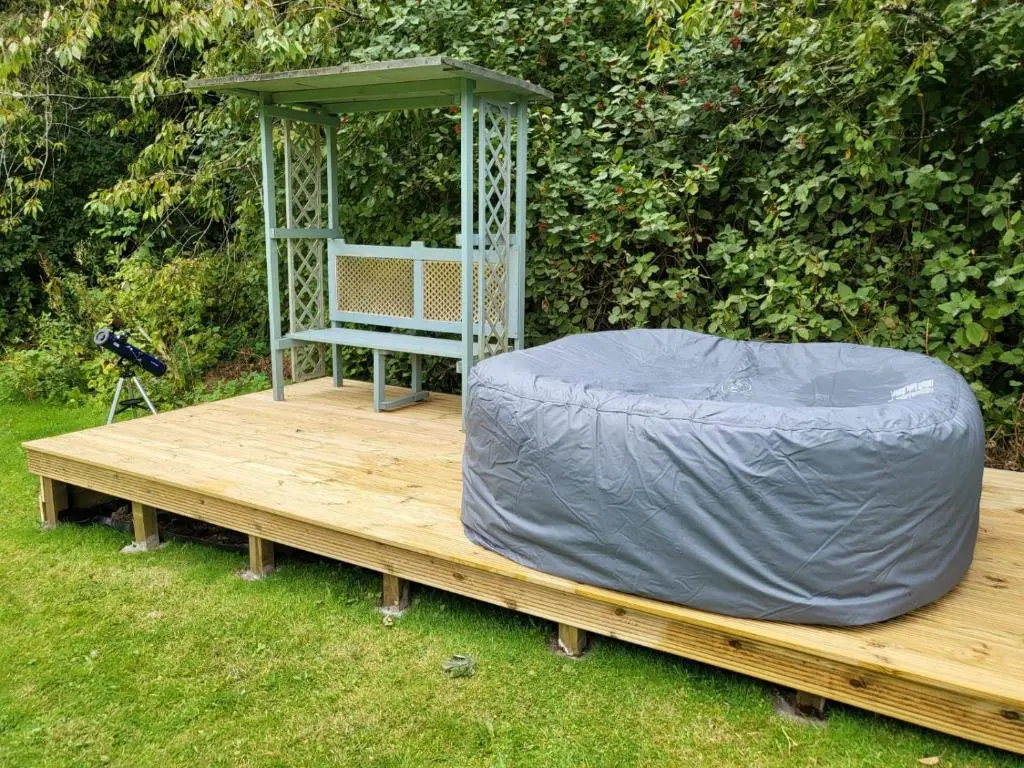 a wooden deck with a gazebo and a bench at East Wing Lickleyhead Castle in Auchleven