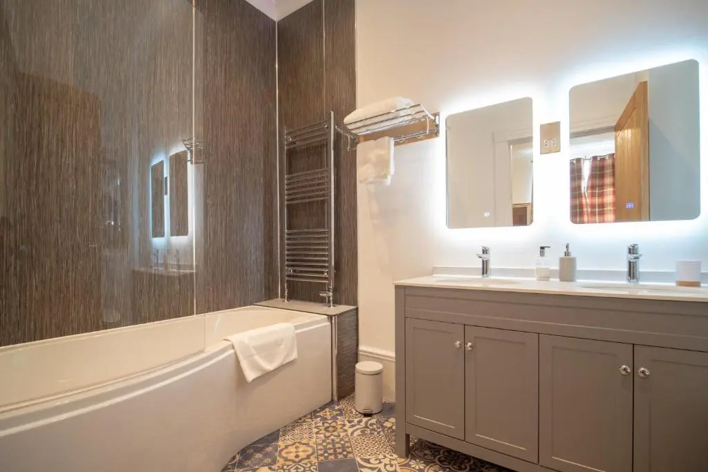 a bathroom with a tub and a sink and a bath tub at Gordonston Apartments in Inverness