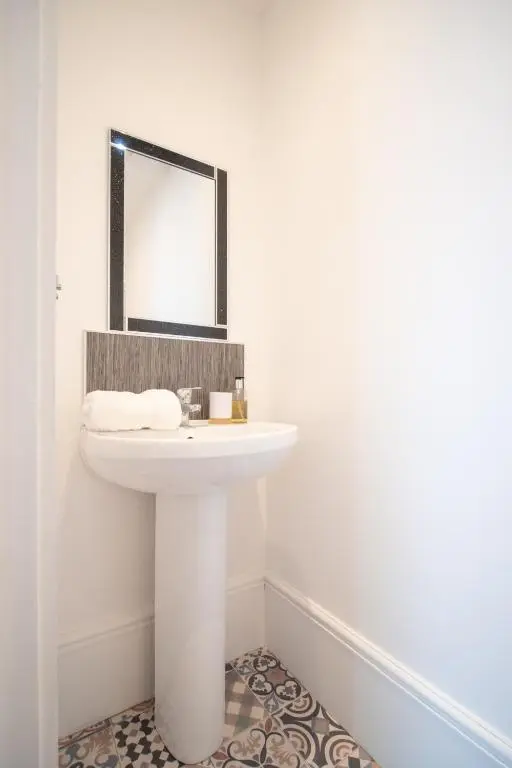 a bathroom with a white sink and a mirror at Gordonston Apartments in Inverness