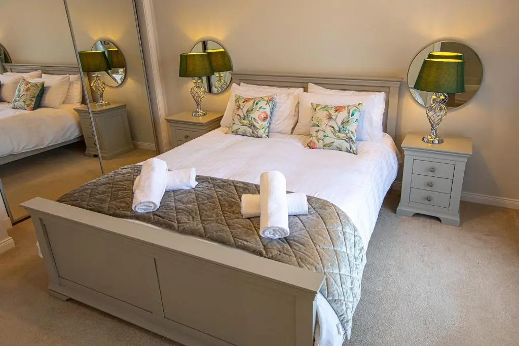 a bedroom with a large bed with towels on it at Hedgefield House - Serene Top Floor Flat in Inverness